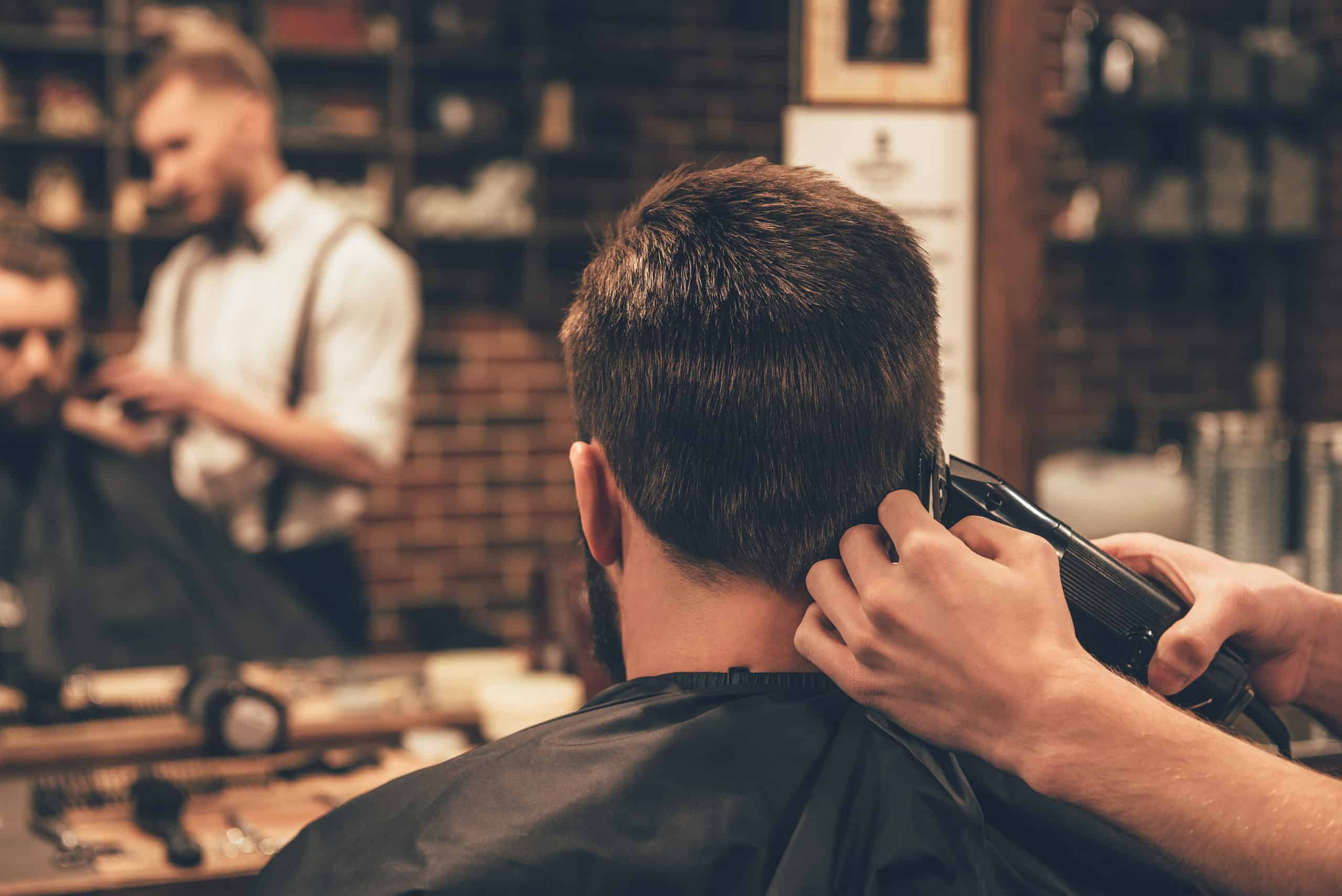 Friseur schneidet einem Mann die Haare im Salon